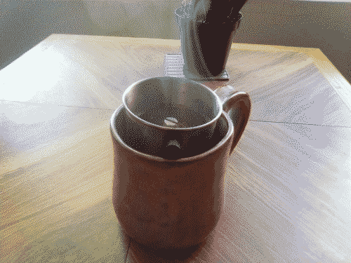 Coffee brewing, ie water filtering through vietnamese steel coffee filter full of beans