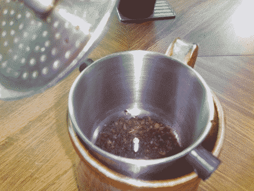 Vietnamese-style steel coffee filter with ground coffee beans