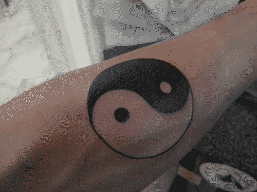 Yin yang tattoo on inner left forearm moments after completion