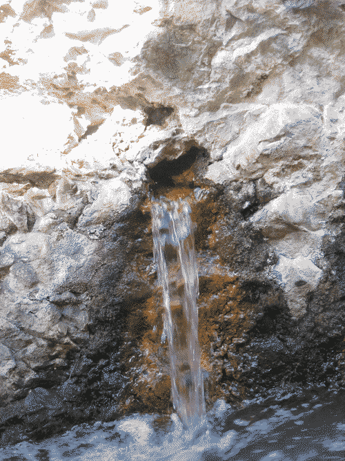 Small stream of water coming out of a rock face at Nambe Falls