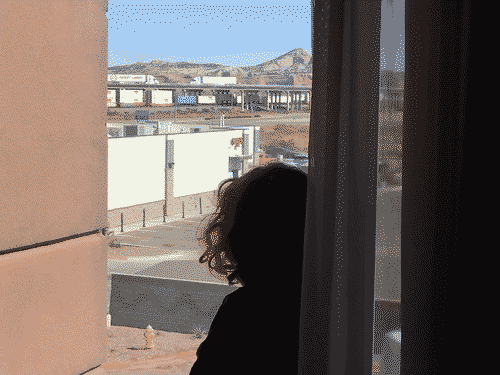 Z looking out the window of a hotel room in Gallup at a freight train