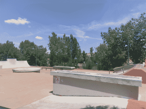 View from De Vargas Skatepark toward the river, with the verdant trees visible beyond the park