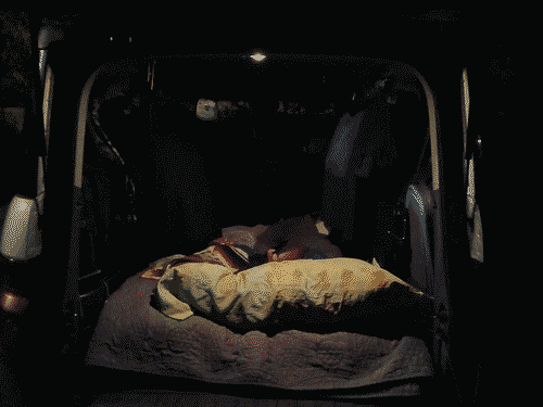 A night photo with the back open and the bed taking up the entire floorspace.