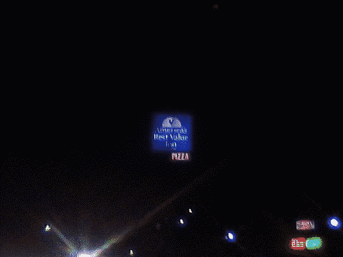 Inn sign at night with promise of pizza