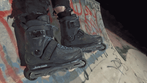 Rollerblade Blank Sean Keane pro skates with blue laces, kizer elements v2 aluminum frames, and slightly larger black wheels on the front and back with more typical aggressive 55-58mm off-white wheels in the middle.